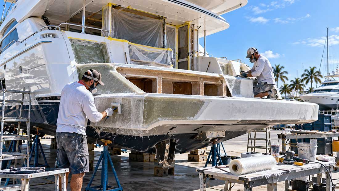 Technicians integrating custom fiberglass fabrication into a yacht