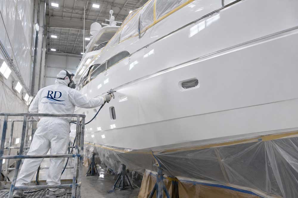 White yacht being professionally spray painted by RD Yacht Refinishing in Fort Lauderdale
